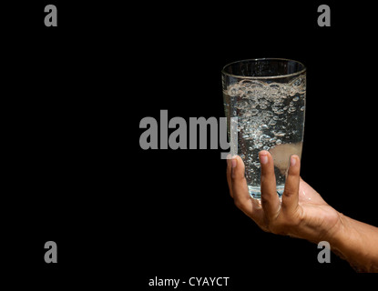 Sprudelnden Wasser in ein Glas von Inderinnen Händen gehalten Stockfoto