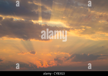 Himmlischen Strahlen des Sonnenlichts durch ein Wolkengebilde über dem Horizont des ruhigen Meeres Stockfoto
