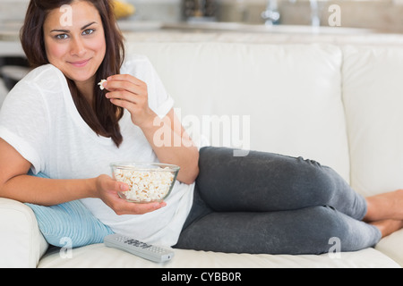 Frau Essen Popcorn und lächelnd Stockfoto