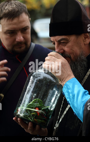 Don Cossack erzählt orthodoxe Priester über alten Kochen Utensil Wodka Infusionen Stockfoto