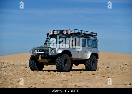 Off Road Expedition vorbereitet 2012 Land Rover Defender 110 mit Ballonreifen Winde, Überrollkäfig, Scheinwerfer auf Sand in Marokko Stockfoto