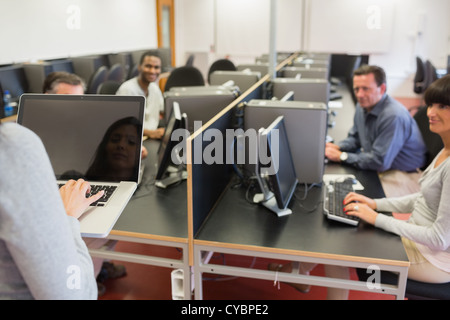Lehrer auf Laptop Computer Klasse eingeben Stockfoto