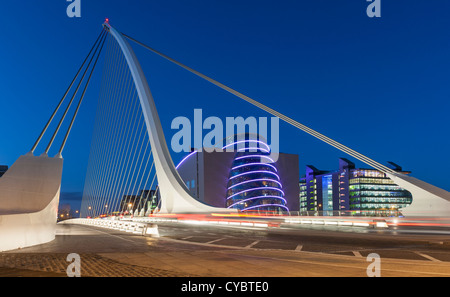 Nacht in Dublin - die Samuel Beckett Bridge über den Fluss Liffey mit dem National Convention Centre im Hintergrund Stockfoto