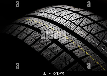 Teil des neuen modernen Auto Winterreifen auf einem schwarzen Hintergrund. Studio gedreht. Stockfoto
