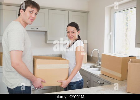 Junges Paar in der Küche-Holding Umzugskartons Stockfoto