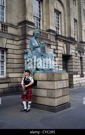 Kaukasischen Mann spielt Dudelsack von Hume Statue außerhalb der High Court of Justiciary, Lawnmarket, Royal Mile in Edinburgh, Schottland Stockfoto