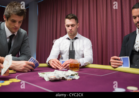 Männer auf der Suche auf ihre Hände in high-Stakes-Poker-Spiel Stockfoto