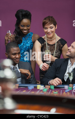 Frauen mit Champagner stand am Roulette-Tisch Stockfoto