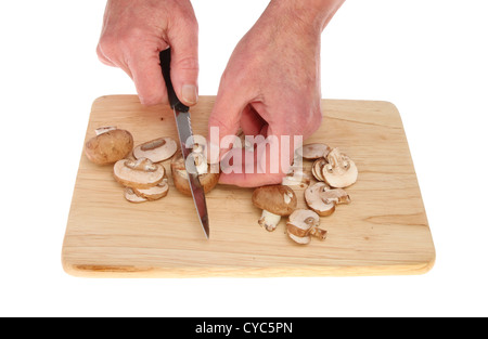 Paar Hände hacken Maronen Pilze auf einem Holzbrett isoliert gegen weiß Stockfoto