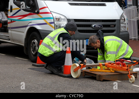 Zwei BT-die Ingenieure im Bild, arbeitet in einem Loch im Boden auf der Straße in Brighton, East Sussex, UK. Stockfoto