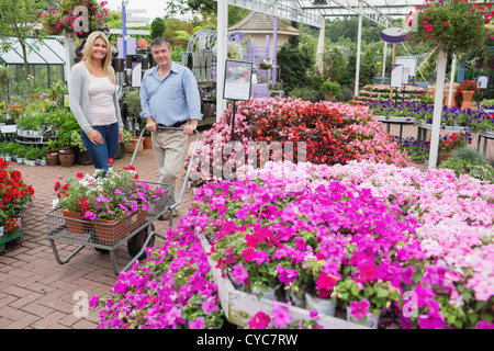 Paar schieben Wagen voller Blumen Stockfoto