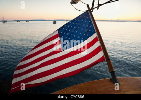 Bei Sonnenaufgang an Bord die Tall ship 'Zodiac' Blick aus dem Heck auf die amerikanische Flagge winken in die Brise in Port Townsend. Stockfoto