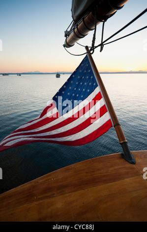 Bei Sonnenaufgang an Bord die Tall ship 'Zodiac' Blick aus dem Heck auf die amerikanische Flagge winken in die Brise in Port Townsend. Stockfoto