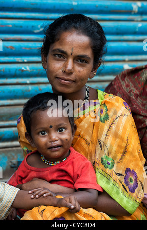 Armen niedrigere Kaste indische Frau mit Baby Junge sitzt auf einer indischen Straße. Andhra Pradesh, Indien Stockfoto