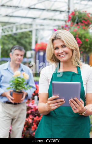 Fröhliche Florist hält einen TabletPC im Garten-center Stockfoto