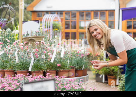 Lächelnde Florist Blick auf Tontöpfen Stockfoto