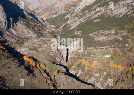 LUFTAUFNAHME. Alpental in Herbstfarben mit der Chatelet Bridge. Saint-Paul-sur-Ubaye, Frankreich. Stockfoto