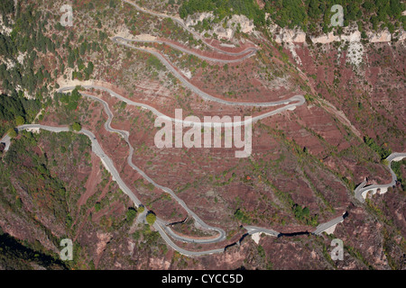 LUFTAUFNAHME. Kurvenreiche Straße auf dem markanten roten Felsen der Daluis-Schlucht. Guillaumes, Var Valley, Hinterland der französischen Riviera, Frankreich. Stockfoto