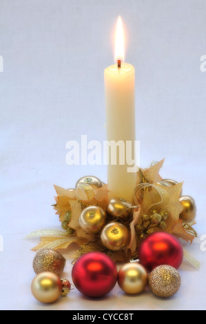 Eine weiße Kerze mit roten und goldenen Kugeln, ein Weihnachten Tisch Dekoration UK Stockfoto