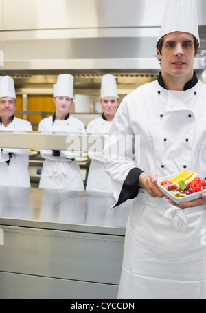 Küchenchef präsentiert Obstsalat Stockfoto