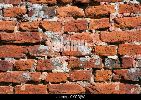 Sehr alte verwitterte, beschädigte, schlecht reparierte handgemachte roten Backsteinmauer hautnah Stockfoto