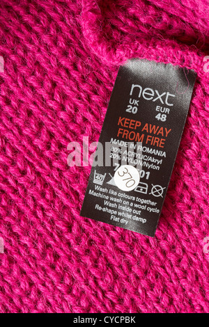 Next Label in rosa Pullover Made in Romania - verkauft in Großbritannien Vereinigtes Königreich, Großbritannien - Pflege waschen Symbole und Anweisungen Stockfoto