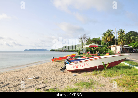 Blauer Himmelsblick nach Union Island, vier weiss rot lackiert Fischerboote am Strandsand auf der Straße, Hillsborough, Carriacou, West Indies Stockfoto