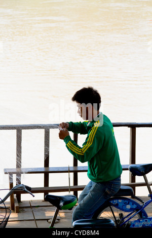 Fischer Reparatur ein Netz an den Ufern des Flusses Mekong in Luang Prabang, Laos Stockfoto