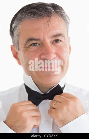 Glücklicher Mann seine Fliege anpassen Stockfoto