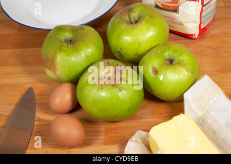 Mehl Eiern Äpfel kochen butter Platte Messer Zutaten um ein hausgemachter Apfelkuchen machen Stockfoto