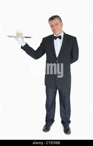 Lächelnden Kellner mit Tablett mit Gläser Whiskey Stockfoto
