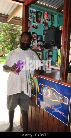 Älterer Mann stehend bar Gießen Drink aus lila Glas in Plastikbecher, Hartholz-Bar und Restaurant, Carriacou, West Indies Stockfoto