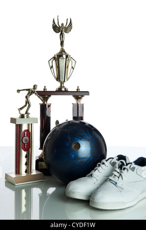 Bowling Ball, Schuhe und Trophäen, die isoliert auf einem weißen Hintergrund und ruht auf einem reflektierenden weißen Tischplatte Stockfoto