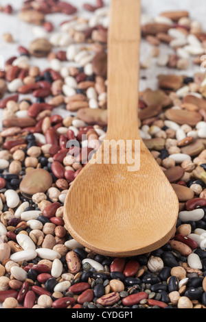 Sortiment von verschiedenen rohen Hülsenfrüchten mit einem Holzlöffel gemischt Stockfoto