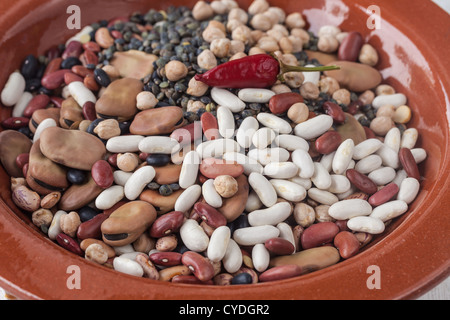 RAW gemischt Hülsenfrüchte in einer keramischen Platte auf den Tisch Stockfoto