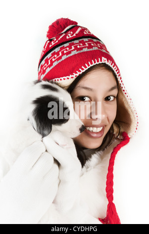 Lächelndes Mädchen im Wintermantel hält einen Border-Collie-Welpen 5 Wochen alt Stockfoto