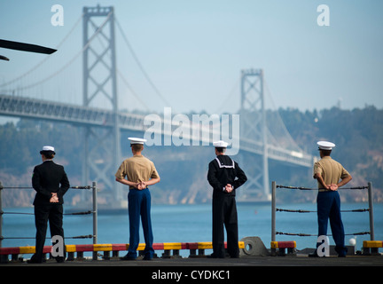 Matrosen und Marinesoldaten Mann die Schienen der amphibischen Angriff Schiff USS Makin Island als das Schiff geht unter der San Francisco Bay Bridge nach Abschluss der San Francisco Fleet Week 9. Oktober 2012 in San Francisco, Kalifornien. Stockfoto