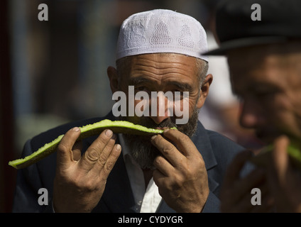 Uyghur Männer Essen Wassermelone, Serik Buya Markt, Yarkand, Xinjiang Uyghur autonome Region, China Stockfoto