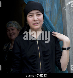 Uyghur Mädchen und ihre Mutter am Eingang von ihrem Haus, Keriya, Xinjiang Uyghur autonome Region, China Stockfoto