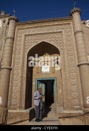 Uyghur Mann am Eingang einer Moschee, Kashgar, Xinjiang Uyghur autonome Region, China Stockfoto