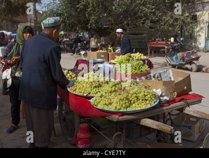 Verkauf von Trauben, Kashgar, Xinjiang Uyghur autonome Region, China Mann Stockfoto