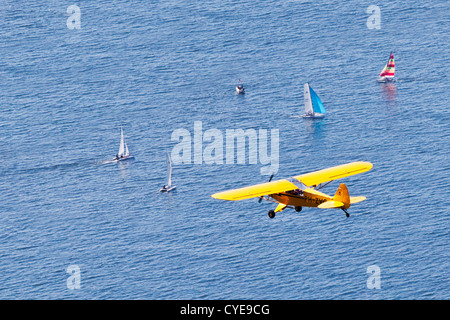 Scheveningen, den Haag. Kleines Flugzeug, eine Piper Cub, fliegen über Katamarane, Segeln in der Nordsee. Luft. Stockfoto