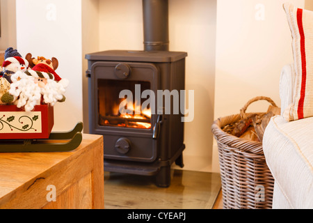 Holzbefeuerter Ofen und Weihnachten Ornamente in einem modernen Wohnzimmer Stockfoto