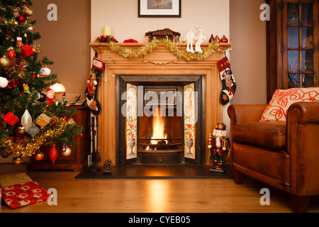 Kamin in einem Einfamilienhaus mit Weihnachtsbaum dekoriert Stockfoto