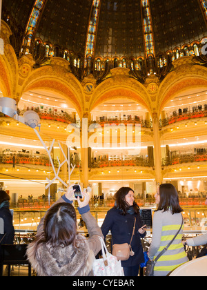 Paris, Frankreich, ein Tourist fotografieren Decke mit Glasmalereien in art Nouveau Architektur an den Galeries Lafayette Stockfoto