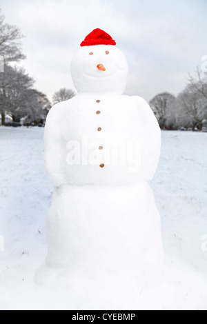 Winterlandschaft mit Schneemann auf einem Dorfplatz in England, UK Stockfoto