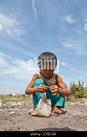 Scavenger-jungen auf der Suche nach elektronischen Bauteile auf der Dump-Website unter Stung Meanchey in Phnom Penh, Kambodscha Stockfoto