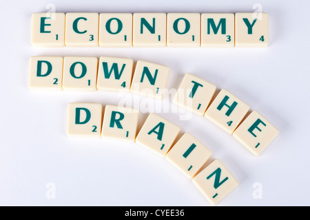 wirtschaftlichen Abschwungs Fliesen Wirtschaft den Bach runter, Konzept-Darstellung mit Scrabble-Buchstaben. Stockfoto