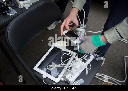 Leute laden ihre Handys und andere elektronische Geräte in Chinatown in New York Stockfoto