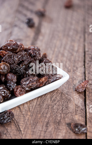 Kleine Platte mit Rosinen auf hölzernen Hintergrund Stockfoto